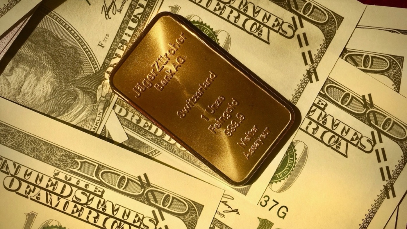 A gold bar on dollar bills